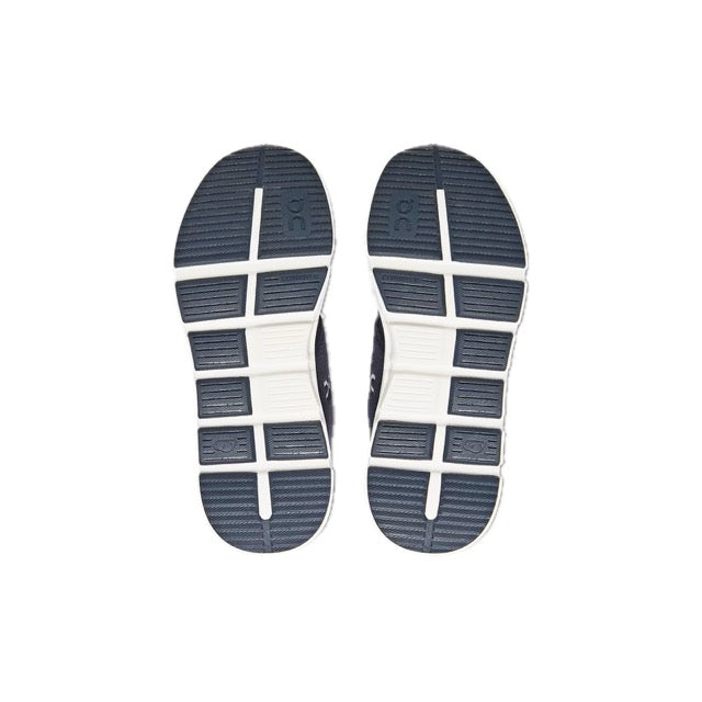 Outsole of the On Kids' Cloud Play in Midnight/White, showing the wide flex grooves and navy rubber wear pads